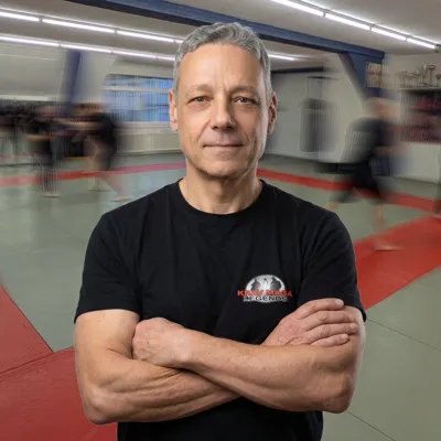 Marcel, Krav-Maga-Instruktor von 2Fight, mit verschränkten Armen im Dojo