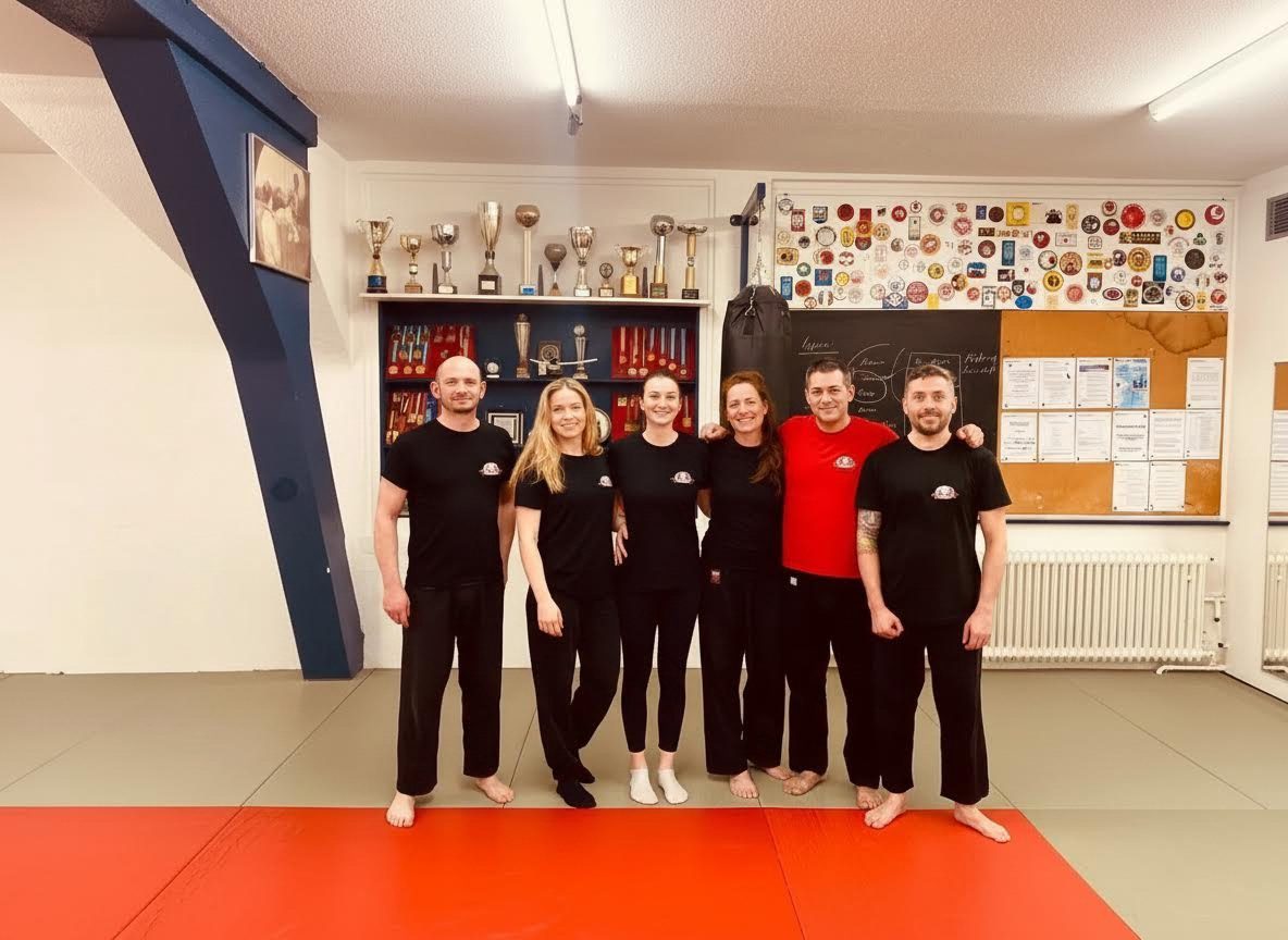 Trainingsgruppe vor der Pokalwand im Dojo