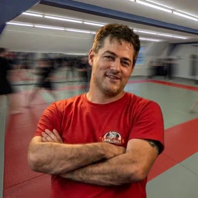 Raoul, Schulleiter von 2Fight, mit verschränkten Armen im Dojo